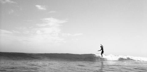 Black and white image of a surfer surfing the famous Rincon Beach.